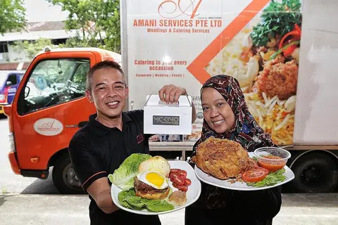 BANGUN PRODUK DAN PERNIAGAAN BARU: Encik Kino (kiri) bersama isteri, Cik Sulastri Embit, menunjukkan produk baru yang sedang dibangunkannya di bawah jenama baru 'McKino' untuk menjual patti daging burger beku berperisa fusion. Beliau turut mencuba beberapa produk lain seperti ayam muda goreng. - Foto BH oleh KEVIN LIM