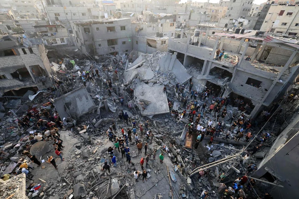 GAZA DIKEPUNG: Penduduk Palestin keluar beramai-ramai bagi memeriksa kerosakan akibat pengeboman tentera Israel ke atas kem pelarian Al-Maghazi di Deir Balah, Gaza, pada Ahad. Kementerian Kesihatan yang dikendalikan Hamas mendakwa serangan tersebut  membunuh 45 orang.