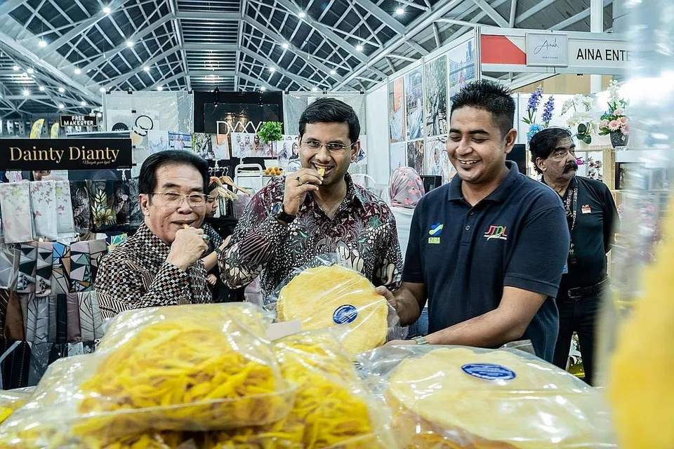 PELBAGAI GERAI: Anggota Parlimen Dilantik (NMP) dan Pengasas Roses of Peace, Encik Mohamed Irshad (tengah) bersama Pengarah Urusan MegaXpress International, Encik Hamzah Abdullah (kiri) bersama penyewa gerai, Encik Adnin Yahya. - Foto BH oleh NUR DIYANAH TAHA