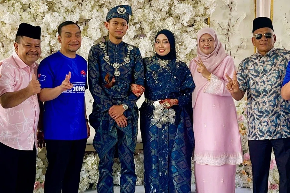 Pengerusi Badan Perhubungan Umno Johor, Datuk Onn Hafiz Ghazi (dua dari kiri), sempat meluang masa untuk menghadiri majlis perkahwinan penduduk, Encik Ahmad Hakim Hasan, 25 tahun; dan Cik Aliah Zulaikha Mohd Nizam, 22 tahun, di Dewan Terbuka Jalan Sekolah, Kampung Seri Lalang.