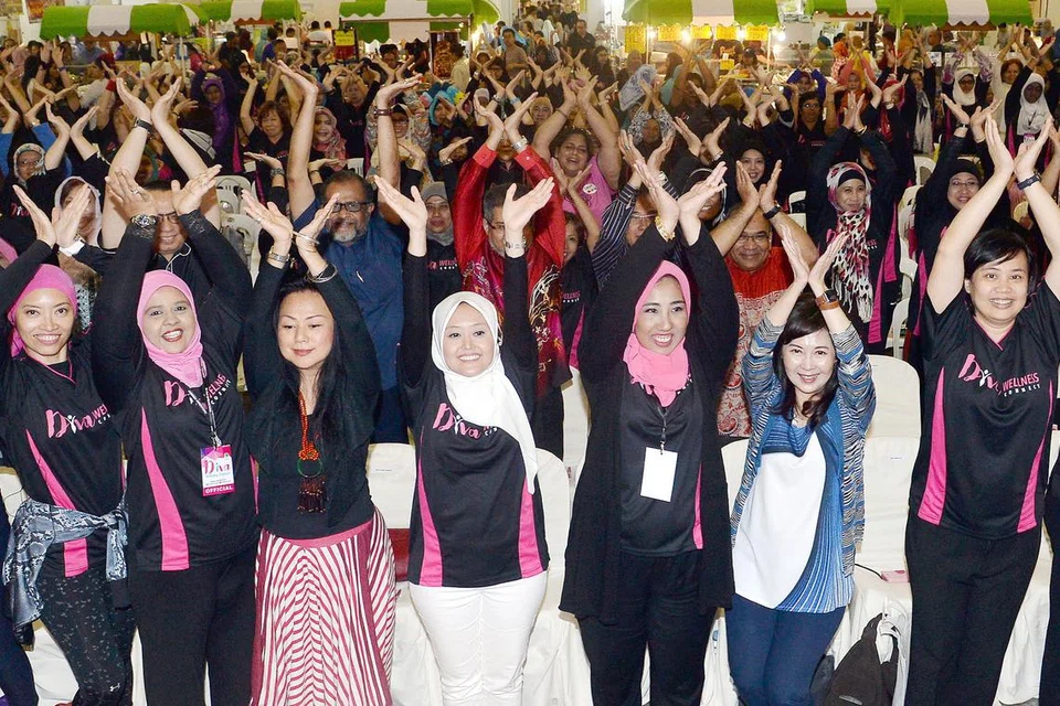 SIHAT SEMUA: Cik Rahayu Mahzam (lima dari kiri) bersama peserta yang mengikuti senaman di pelancaran 'Diva Welness Connect' di Singapore Expo kelmarin. - Foto TAUFIK A. KADER
