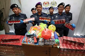 Timbalan Ketua Pengarah Kastam (Penguatkuasaan & Pematuhan) Datuk Sazali Mohamed (tengah), menunjukkan rokok putih dan mainan plastik yang dirampas dalam sebuah kontena ketika pemeriksaan di Pelabuhan Tanjung Pelepas.