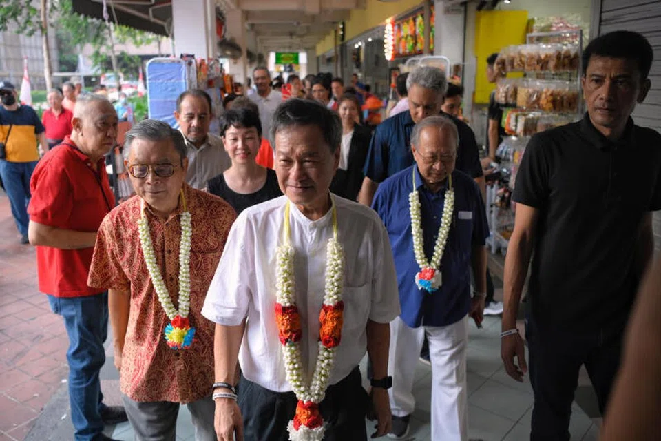 LAWATAN KE PASAR: Calon Presiden Pilihan Raya, Encik Tan Kin Lian, melawat Pusat Makanan People’s Park pada Ahad pagi, diiringi Encik Tan Jee Say (kiri) dan Dr Tan Cheng Bock (kanan).