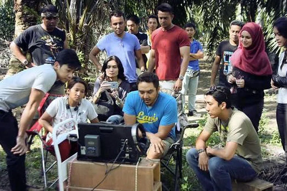 GALAK ANAK SENI TEBAR SAYAP DI MALAYSIA: Pengarah berpengalaman, Nizam Zakaria (duduk, tengah), berkata anak seni Singapura memiliki ilmu dan kemahiran teknikal yang baik untuk mengecapi kejayaan di Malaysia. Beliau ditemui di kawasan Chinatown baru-baru ini.