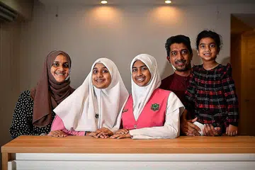 AKTIF DI SEKOLAH: Meskipun perlu mempersiapkan diri untuk menghadapi peperiksaan penting, Ayra (tengah) kekal aktif menyumbang di sekolah. Ibu bapanya Encik Mohammed Kutty (dua dari kanan) dan Cik Shifa Kammana Abdulla (kiri) sentiasa memberi kata perangsang. Turut bergambar bersama mereka adalah adik Ayra, Naurah (kanan) dan Sarah (dua dari kiri). - Foto BH oleh LIM YAOHUI