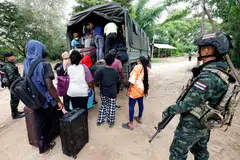 Orang ramai dari pelbagai negara yang bekerja di kompleks KK Park di Myanmar menaiki kenderaan selepas menyeberangi Sungai Moei ke Thailand, sementara askar Thai mengawal kawasan di Daerah Mae Sot, Wilayah Tak pada 24 Oktober 2025. Lebih daripada 1,000 orang dilaporkan melarikan diri dari Myanmar ke Thailand minggu ini selepas tentera Myanmar menyerbu salah satu pusat penipuan terbesar di negara itu.