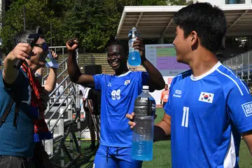 Pelarian Cameroon, Fossi Wandji (tengah) meraikan kemenangan bersama rakan sepasukan selepas perlawanan antara Korea Selatan dengan Switzerland.