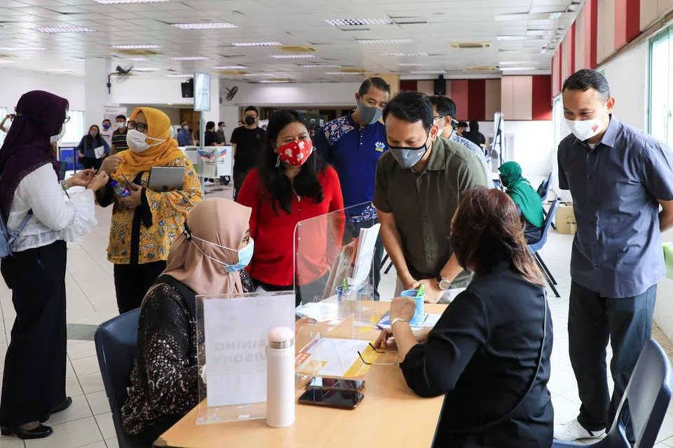 (Dari kanan) AP GRC Marine Parade, Encik Mohd Fahmi Aliman; Menteri Negara Kanan (Tenaga Manusia merangkap Pertahanan), Encik Zaqy Mohamad; dan AP GRC Sembawang, Cik Mariam Jaafar, berinteraksi dengan pencari kerja dalam satu pameran kerjaya yang diadakan di Kelab Masyarakat Marsiling sempena pelancaran Bidang Tumpuan Empat M³ mengenai pekerjaan pada Oktober 2020.