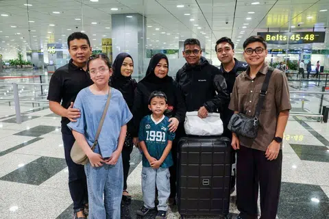 Encik Abdul Rahim Abdullah (tiga dari kanan) disambut keluarganya, termasuk anaknya, Encik Amirul Asraff Abdul Rahim (dua dari kanan) sebaik sahaja beliau selamat tiba di Singapura pada 7 Mac sekitar 9.20 malam.
