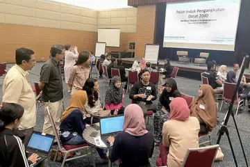 HANGAT BINCANG: Dr Faishal (berdiri, dua dari kiri) sedang menyaksikan sekumpulan peserta membincangkan isu-isu Pelan Induk Pengangkutan Darat 2040 yang diadakan di auditorium Singapore Press Holdings (SPH) kelmarin. - Foto BH oleh NAZRI HADI