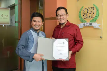 DIBERI PENGIKTIRAFAN: Institut Pengajian Al-Zuhri menerima sijil Kelas Mutu Singapura (SQC) setelah tiga tahun membuat persediaan dan permohonan. Dalam gambar adalah Pengarah Jabatan Pengurusan Al-Zuhri, Dr Abullah Othman (kanan) dan Pengarah Eksekutif, Ustaz Mas'udin Syarifuddin (kiri). - Foto BH oleh SINTARO TAY