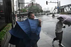 Pejalan kaki terkial-kial dengan payung mereka dalam angin kencang dan hujan lebat akibat taufan, ‘Bebinca’, di Shanghai pada 16 September. 