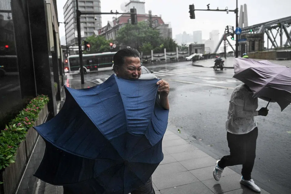 Pejalan kaki terkial-kial dengan payung mereka dalam angin kencang dan hujan lebat akibat taufan, ‘Bebinca’, di Shanghai pada 16 September. 
