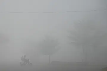 Seorang penunggang motosikal melalui jalan yang diselubungi jerebu akibat kebakaran hutan dan tanah di Banyuasin, Sumatera Selatan, Indonesia, pada 23 Ogos 2026. Presiden Indonesia, Encik Prabowo Subianto, mengarahkan tindakan pantas dan bersepadu untuk memadam kebakaran, selain penguatkuasaan tegas terhadap individu serta syarikat yang terbukti melakukan pembakaran secara haram. Pemerintah turut mengerahkan pasukan khas TNI dan menambah operasi pengeboman air di kawasan yang sukar dicapai.