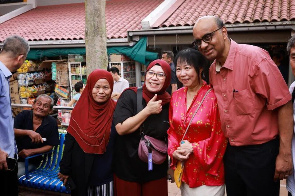 BERPENGALAMAN DEKATI MASYARAKAT UMUM: Encik Tharman Shanmugaratnam (kanan) dan isteri, Cik Jane Ittogi (dua dari kanan) bergambar dengan warga Singapura di estet kejiranan Teck Whye. Pengalaman Encik Tharman sebagai ahli politik selama lebih dua dekad membuatnya lebih dikenali orang awam berbanding dua pesaingnya.