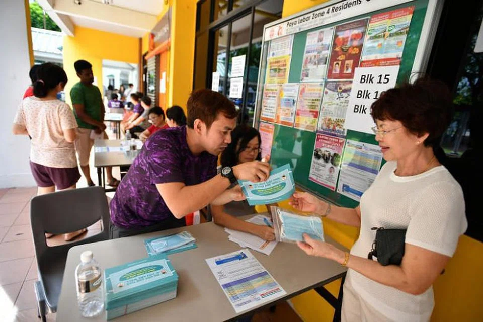 Soerang wanita sedang menerima pelitup percuma di Hougang pada 1 Februari 2020. - Foto: Lim Yaohui 