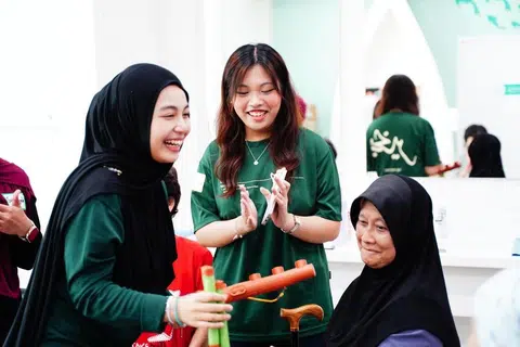 Pengarah Projek BeKhayr, Cik Nur Ariana Azman (tengah), membimbing warga emas dalam permainan menangkap baton untuk menguji ketangkasan masing-masing.