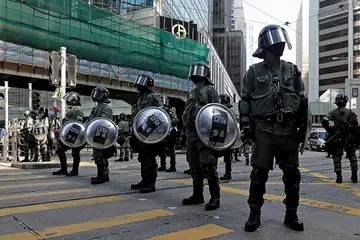 BANTAHAN: Polis pencegah rusuhan berdiri di tengah-tengah jalan raya di kawasan Central, Hong Kong semalam. - Foto Reuters.