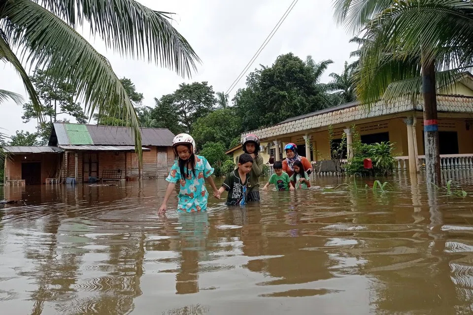 MERSING DILANDA BANJIR: Penduduk Kampung Tenglu Besar di Mersing, Johor, meredah air berikutan kediaman mereka dilanda banjir  susulan pertembungan air pasang besar dan hujan lebat yang berterusan.