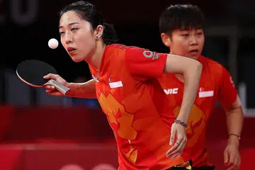 MARA KE SUKU AKHIR: Pasangan beregu tenis meja Singapura Yu Mengyu (kiri) dan Lin Ye (kanan) ketika beraksi menentang Perancis dalam acara pasukan wanita di Gimnasium Metropolitan Tokyo semalam. - Foto REUTERS