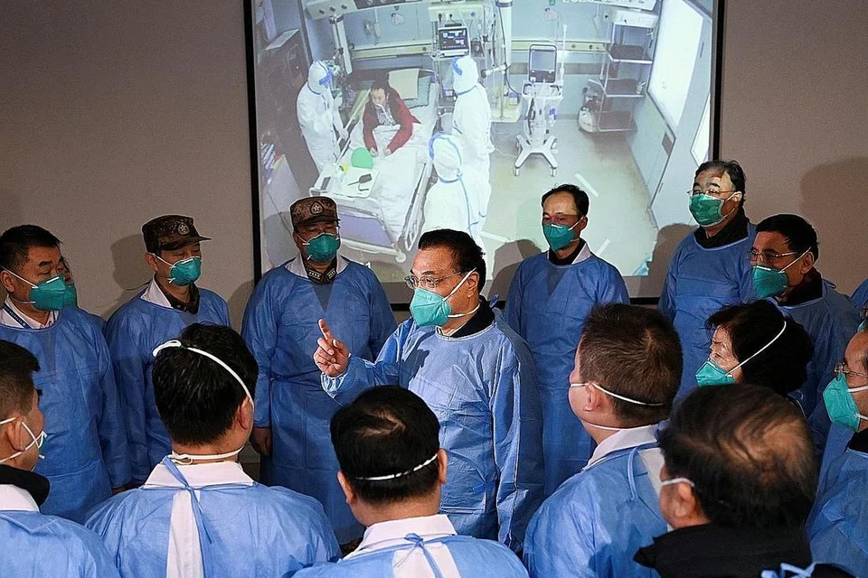 BINCANG LANGKAH: Perdana Menteri China Li Keqiang (tengah), memakai pelitup dan pakaian pelindung, bersama kakitangan perubatan ketika melawat Hospital Jinyintan di Wuhan di mana para pesakit yang telah dijangkiti koronavirus dirawat.- Foto REUTERS