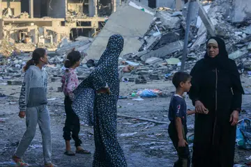 MUSNAH TERUK: Penduduk Palestin berjalan di tengah-tengah runtuhan bangunan yang musnah akibat serangan Israel di di selatan Jaluran Gaza pada 16 Oktober 2023.