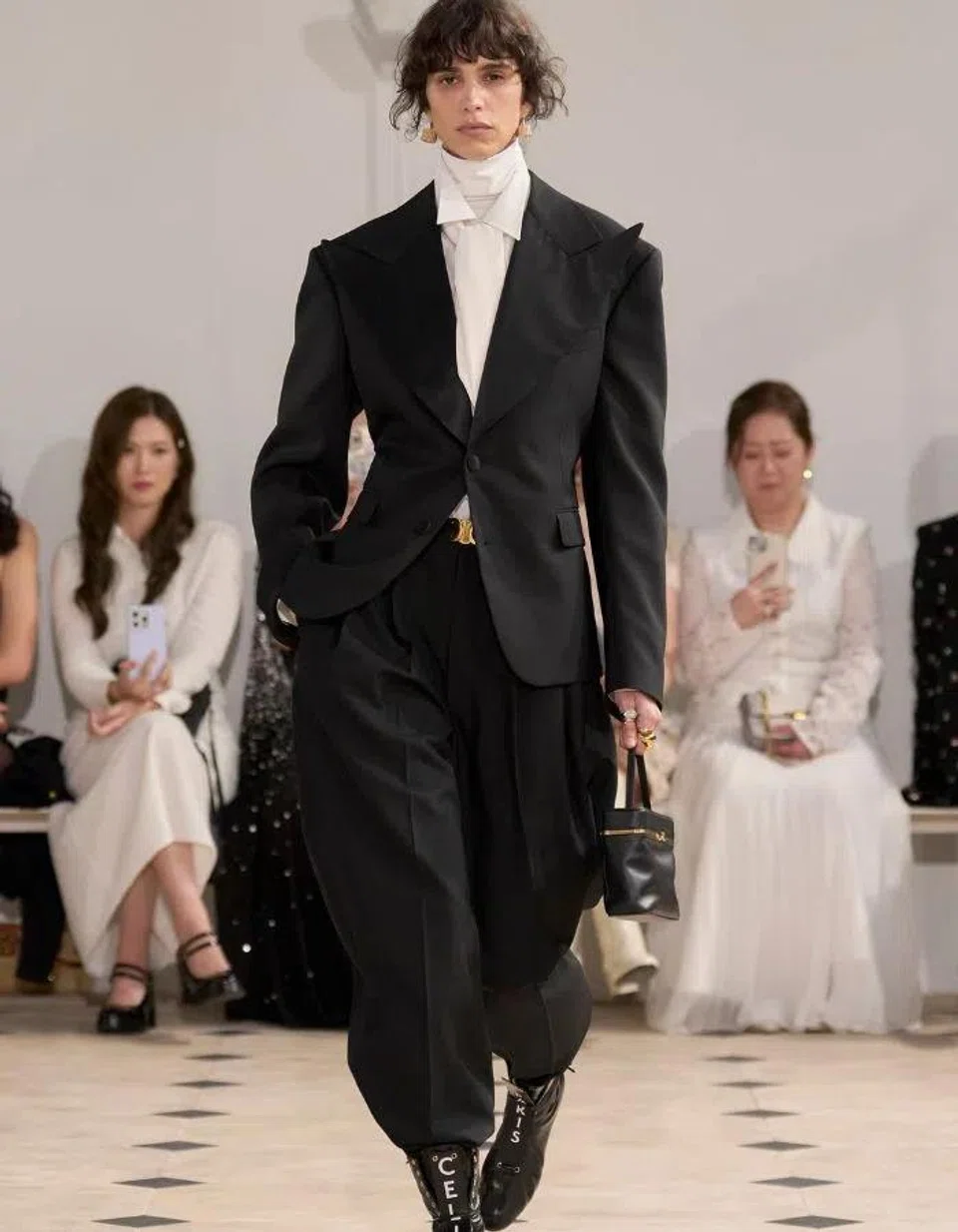 Padankan kemeja putih formal ala gaya ‘white-on-white’ leher penyu Celine, dengan sut hitam untuk mencipta penampilan yang sofistikated dan berani.