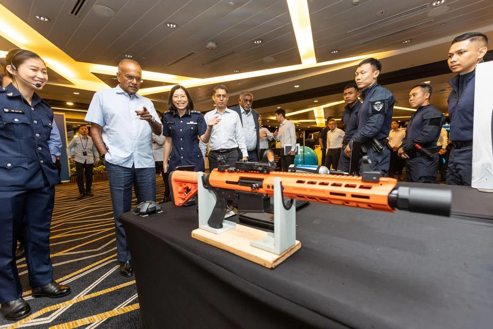 TINJAU PAMERAN: (Dari kiri) Encik K Shanmugam, Cik Shie Yong Lee dan Dr Muhammad Faishal Ibrahim meninjau satu pameran dan bertemu pasukan Respons Tindakan Kecemasan Penjara Singapura (SPEAR) yang menerangkan tentang peralatan yang dipertingkatkan, seperti senapang separa automatik Bryna Less Lethal Pistol dan the Genesis, oleh Perkhidmatan Penjara Singapura demi meningkatkan penjagaan selamat dan terjamin bagi banduan. - Foto ZAOBAO