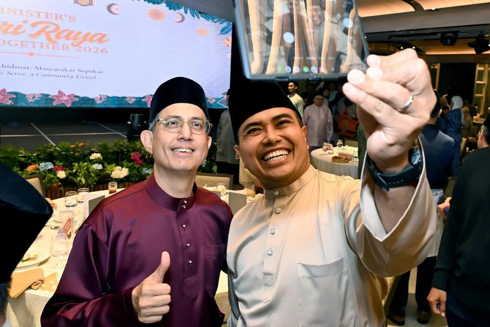 Anggota Parlimen (AP) GRC Pasir Ris-Changi, Encik Sharael Taha (kanan) mengambil gambar swafoto bersama Pemangku Menteri Bertanggungjawab bagi Ehwal Masyarakat Islam, Profesor Madya Dr Muhammad Faishal Ibrahim di Perjumpaan Hari Raya Menteri di Hotel Parkroyal Collection Marina Bay pada 10 April.