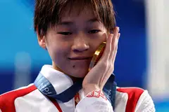 Pemenang pingat emas Hongchan Quan dari China meraikan kemenangan dengan pingat emas dalam genggamannya.