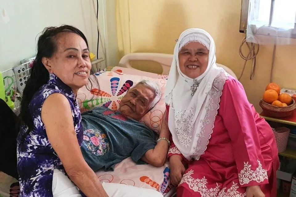 SAMBUTAN BERBEZA WALAU SATU KELUARGA ASALNYA: Cik Fatimah Mohidin (kanan) dan Cik Thangah Koh (kiri) menyambut Tahun Baru Cina bersama mendiang ibu kandung mereka pada 2020.