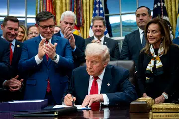 Presiden Amerika Syarikat Donald Trump (tengah) menandatangani pakej pembiayaan untuk membuka semula pemerintah persekutuan di Pejabat Oval, Rumah Putih di Washington, D.C., Amerika Syarikat, pada 12 November.