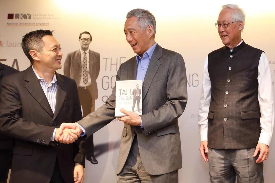 AUTOBIOGRAFI DILANCAR: Penulis buku 'Tall Order: The Goh Chok Tong Story', Encik Peh Shing Huei (kiri) menyerahkan senaskhah autobiografi itu kepada Perdana Menteri Lee Hsien Long dalam satu majlis pelancaran pada Khamis lalu, dengan disaksikan ESM Goh. - Foto BH oleh GAVIN FOO 
