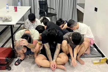 Beberapa suspek dengan tangan diikat menggunakan tali zip selepas ditahan dalam satu serbuan polis ke atas pusat penipuan di Phnom Penh, Kemboja, pada 16 Julai 2025. Operasi ini merupakan sebahagian daripada tindakan keras di seluruh negara terhadap rangkaian jenayah siber, susulan arahan Perdana Menteri Hun Manet untuk menutup operasi penipuan dalam talian yang sering dikendalikan seperti kilang buruh paksa.