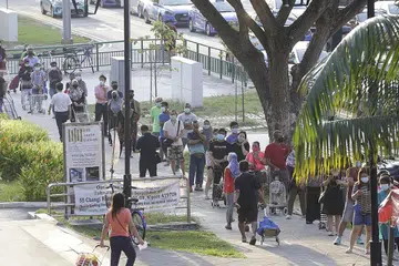 BERATUR PANJANG: Ramai orang kelihatan beratur di Pasar Geylang Serai menantikan giliran dibenarkan masuk untuk berbelanja. Ada pengunjung ke pasar itu berkata mereka datang seawal 6 pagi sebelum ia sesak bagi menyingkatkan masa menunggu sebelum masuk. - Foto BM oleh AZMI ATHNI
