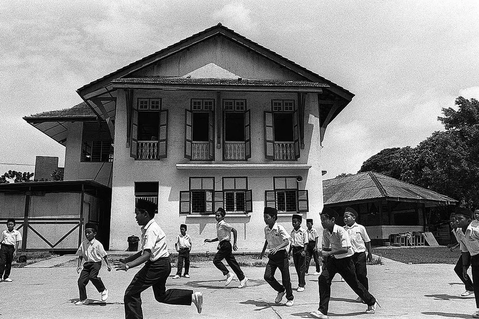 PENUH SEJARAH: Sekumpulan murid kelihatan bermain di sekitaran bangunan lama Madrasah Aljunied. Bangunan itu telah dirobohkan pada 1996 untuk memberi laluan kepada pembinaan bangunan baru madrasah yang masih berdiri masa kini. - Foto fail