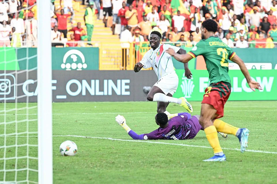  GOL PERTAMA: Pemain tengah Guinea, Mohamed Bayo (jersi putih) menjaringkan gol pertama pasukannya pada minit ke-10 semasa perlawanan bola sepak peringkat awal Piala Negara-Negara Afrika (Afcon)  antara Cameroon dengan Guinea di Stadium Charles Konan Banny, Yamoussoukro pada 15 Januari.
