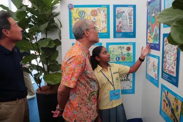 HARUS JIMAT GUNA AIR: Encik Masagos Zulkifli bersama pelajar Sekolah Rendah Changkat, Shruthi Suresh yang menyertai pameran menghargai sumber air setempat. - Foto BM oleh JASON QUAH