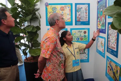 HARUS JIMAT GUNA AIR: Encik Masagos Zulkifli bersama pelajar Sekolah Rendah Changkat, Shruthi Suresh yang menyertai pameran menghargai sumber air setempat. - Foto BM oleh JASON QUAH