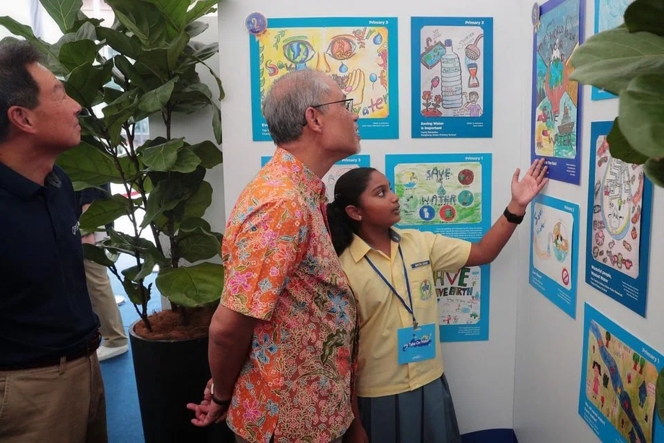HARUS JIMAT GUNA AIR: Encik Masagos Zulkifli bersama pelajar Sekolah Rendah Changkat, Shruthi Suresh yang menyertai pameran menghargai sumber air setempat. - Foto BM oleh JASON QUAH