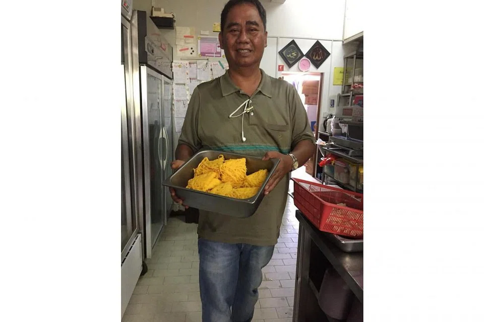 SIBUK: Encik Zainuddin Sajat dengan tempahan makanan yang dipesan pelanggannya, sambil mengawasi kerja katering Hari Raya di dapur pusat syarikat beliau. - Foto ihsan ZAINUDDIN SAJAT