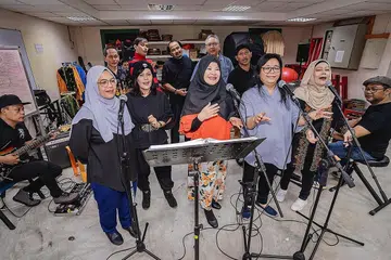SATU HATI DEMI NOSTALGIA: Alumni Adubakat 1986 yang terdiri daripada (barisan depan, dari kiri) Asiyah Sinnan, Juliana Samat, Rosezita Rusli, Rizana Adnan dan Suliah Kasmadi, serta (barisan belakang, dari kiri) Jalil Yani, Sabarudin Leman, Azman Shariff, Azhar Ahmad dan Othman Abdullah, gigih berlatih bagi acara makan sambil berhibur di Holiday Inn Singapore Orchard City Centre, Ahad ini.