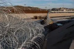 PUNCA ISU: Pagar dawai di sempadan Amerika-Mexico di Sungai Tijuana di negeri Baja California. Presiden Trump mahu membina tembok konkrit bagi menghalang pendatang haram, seperti rakyat Hondura ini, yang memanjat pagar di sempadan itu pada 6 Januari lalu ini untuk memasuki Amerika. - Foto AFP