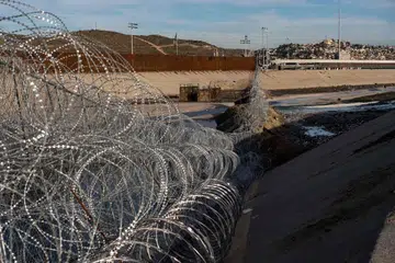 PUNCA ISU: Pagar dawai di sempadan Amerika-Mexico di Sungai Tijuana di negeri Baja California. Presiden Trump mahu membina tembok konkrit bagi menghalang pendatang haram, seperti rakyat Hondura ini, yang memanjat pagar di sempadan itu pada 6 Januari lalu ini untuk memasuki Amerika. - Foto AFP