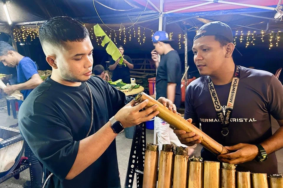 Pengasas De’ Lemang, Encik Nurfaliq Ilman Yadzuzd (kiri), bersama Pengurus De’ Lemang, Encik Fakhri Zunnurain Mohd Jais, memeriksa mutu lemang yang baru selesai dimasak.