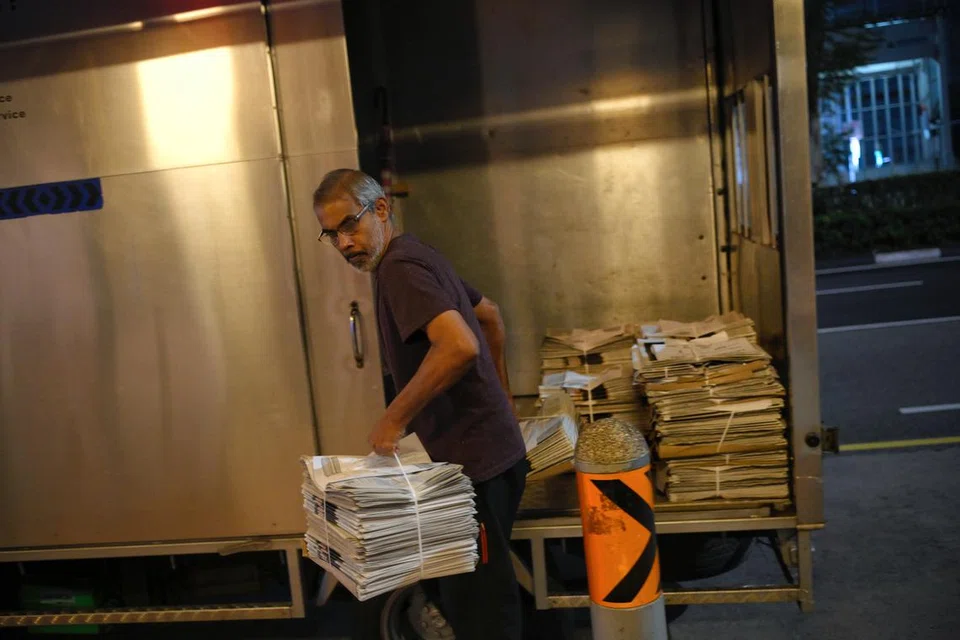 AMBIL BEKALAN: Akhbar dihantar dari Pusat Cetak SPH di Jurong ke 154 tempat sekitar Singapura, termasuk di sepanjang Beach Road tempat Encik Kumar mengumpul bekalannya setiap hari.