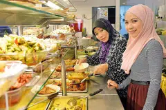 TEBAR SAYAP: Cik Mastura (kanan) berkata langkah membuka tujuh gerai 'mini' di serata Singapura itu bertujuan memastikan pelanggan tidak perlu ke dua restoran Hajah Maimunah - di Jalan Pisang dan Joo Chiat - untuk mendapatkan makanan kegemaran mereka. Gambar menunjukkan Cik Mastura dan ibunya, Cik Mahiran Abdul Rahman, di cawangan sedia ada.- Foto BM oleh KHALID BABA