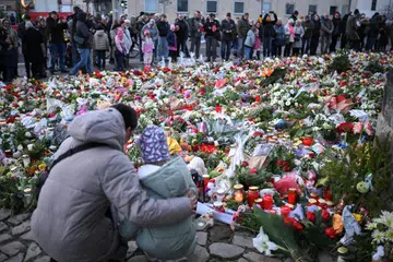 
Orang ramai meletakkan jambangan bunga dan menyalakan lilin pada 22 Disember sebagai penghormatan berhampiran pasar Krismas, ‘Alter Markt’, lokasi seorang lelaki memandu kereta ke arah orang ramai melalui laluan kecemasan pada 20 Disember di Magdeburg, Jerman.