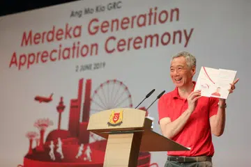 GENERASI MERDEKA: Encik Lee menunjukkan folder Generasi Merdeka yang diberikan kepada 8,300 warga Singapura menerusi pelbagai acara kemasyarakatan di seluruh negara hari ini.