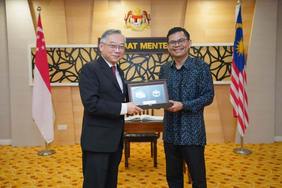 Menteri Ekonomi Malaysia, Encik Akmal Nasrullah Mohd Nasir (kanan), menyampaikan cenderamata kepada Timbalan Perdana Menteri Singapura merangkap Menteri Perdagangan dan Perusahaan serta Menteri Bertanggungjawab bagi Tenaga, Encik Gan Kim Yong, di pejabatnya di Kementerian Ekonomi, Putrajaya.